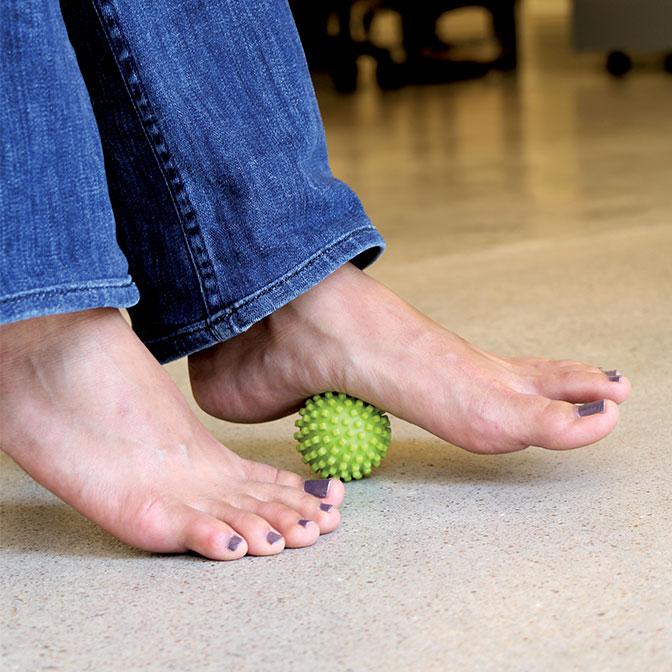 Woman massaging her foot with Mobipoint Massage Ball